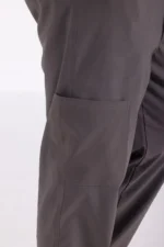 Close-up of dark gray pants showing a side pocket, highlighting utility and casual style. The fabric appears durable and comfortable.